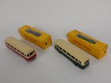 three toy buses are lined up next to each other on a white surface