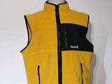 un gilet jaune et noir posé sur un présentoir à mannequin