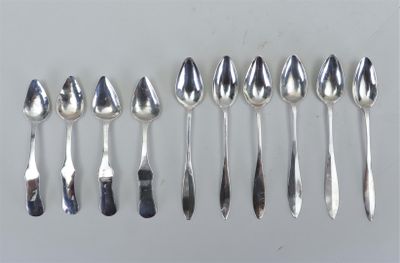 six cuillères et une fourchette sont alignées sur une table