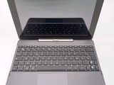 a silver laptop with a black keyboard on a white surface