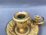 une tasse et une soucoupe dorées posées sur un napperon bleu