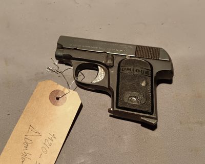 a small gun with a tag on it sitting on a table