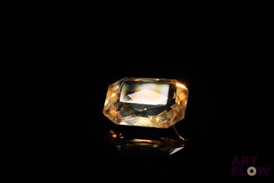 a close up of a yellow diamond on a black surface