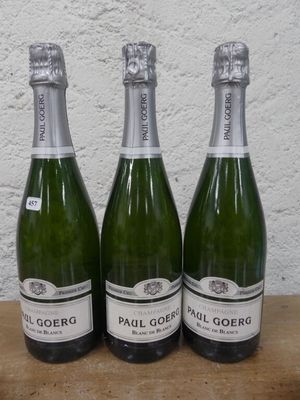 trois bouteilles de champagne posées sur une table l'une à côté de l'autre
