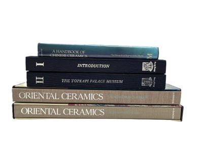 trois livres empilés sur une surface blanche