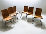Plusieurs chaises sont disposées en cercle dans une pièce blanche.