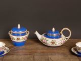 un service à thé en trois pièces, en porcelaine bleue et blanche, posé sur une table en bois