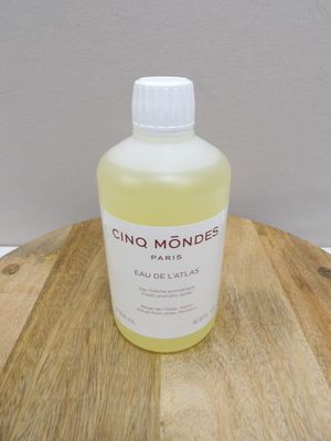 une photo d'une bouteille de liquide posée sur une table en bois