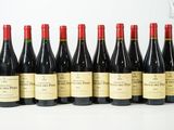 six bouteilles de vin sont alignées sur une table