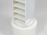 a small white cabinet with shelves on top of it