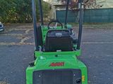 a small green tractor parked in a parking lot