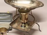 a silver plate with a silver cup on it next to a silver tray with a silver cup on it