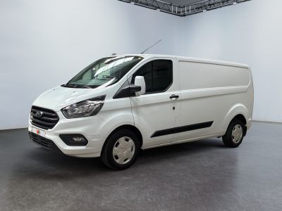 La camionnette blanche est garée à l'intérieur d'une grande pièce blanche.