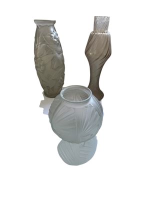 trois vases posés l'un à côté de l'autre sur une surface blanche