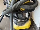 a yellow and black vacuum sitting on the floor next to a wall
