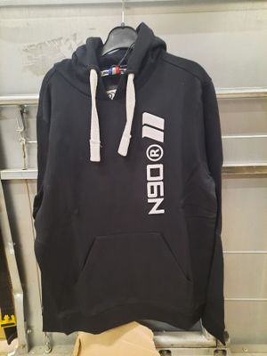 black hoodie with white logo on it hanging on a rack in a garage