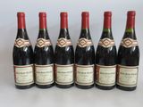 six bottles of red wine lined up in a row on a table
