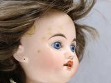 a close up of a doll with hair blowing in the wind