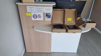 un petit bureau sur lequel se trouvent un ordinateur portable et plusieurs boîtes