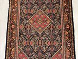 un tapis ancien orné d'un motif en losanges sur fond blanc
