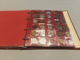a red book with a bunch of coins inside of it