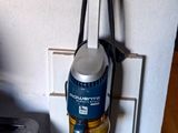 un aspirateur posé par terre à côté d'une cuisinière