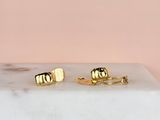 a pair of gold stud earrings sitting on top of a marble slab