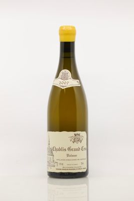 the bottle of white wine is sitting on a white surface