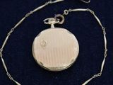 a close up of a gold locke on a chain with a chain around it