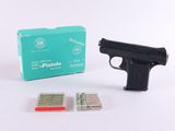 un pistolet et une boîte de cartouches posés sur une surface blanche