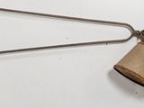 an image of a wooden bell hanging from the side of a wall