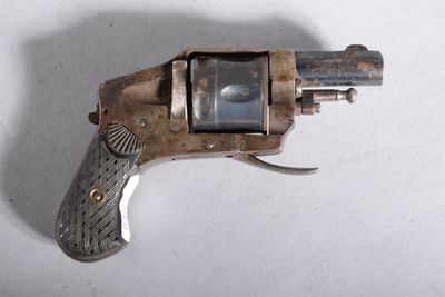 un petit pistolet posé sur une surface blanche