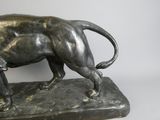 bronze statue of a lion on a rock on a white background