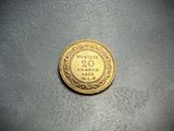 a close up of a gold coin on a gray surface