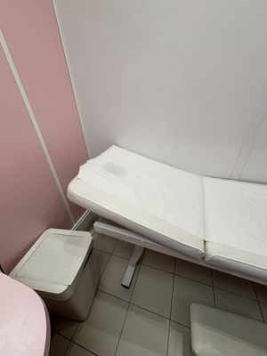 des toilettes roses et un lit blanc dans une petite chambre