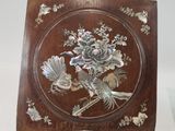 a wooden plaque with a bird and flowers on it