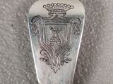 a silver spoon with a crown on it sitting on a table