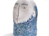a ceramic sculpture of a man ' s face with a wave coming out of it