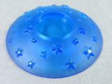 a blue candle holder with stars on it on a table