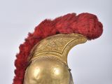 an old helmet with a red feather on top of it