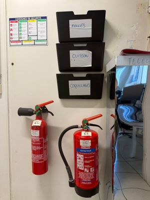 two fire extinguisors on the wall next to a door