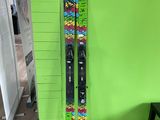des skis et des bâtons de ski appuyés contre un mur vert, devant un mur vert