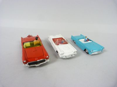 trois voitures jouets assises l'une à côté de l'autre sur une table