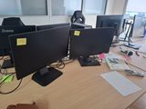 three computer monitors sitting on a desk next to each other