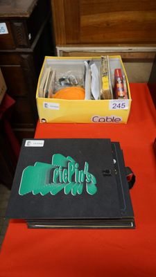 une table rouge sur laquelle se trouvent un livre noir et une boîte jaune