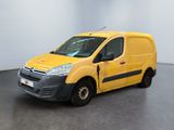 La camionnette jaune est garée dans une pièce blanche au sol noir.