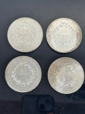 four silver coins are on display in a glass case