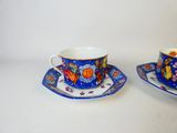 two cups and saucers sitting on a white table