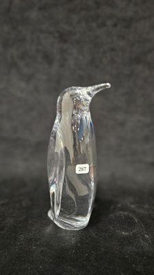 an image of a glass penguin figurine sitting on a black surface