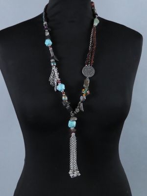 une femme portant un collier composé de perles et d'un pompon